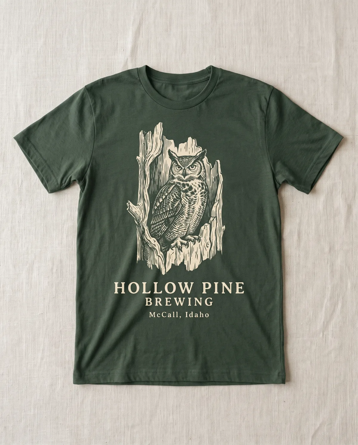 Tee with an engraved great horned owl in a hollow pine for Hollow Pine, McCall Idaho